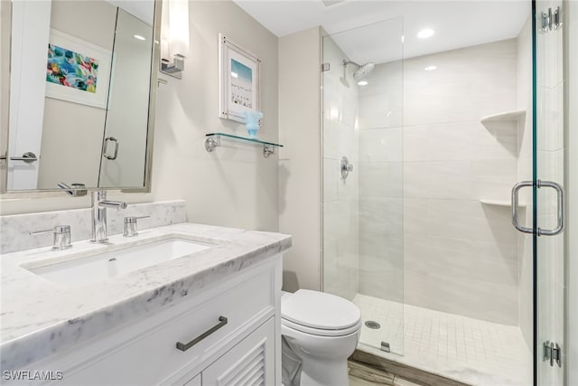 bathroom featuring walk in shower, toilet, vanity, and hardwood / wood-style flooring