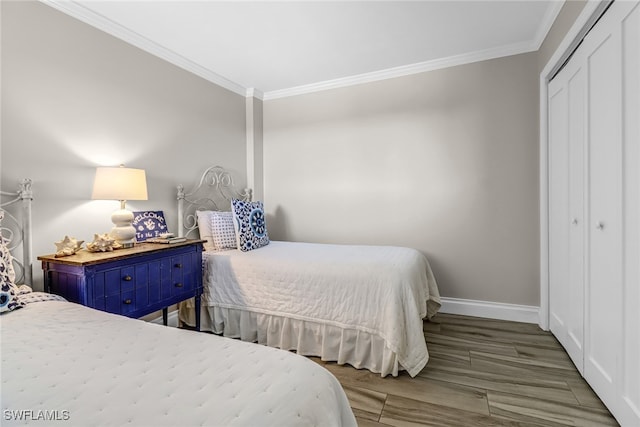 bedroom with wood-type flooring, a closet, and crown molding