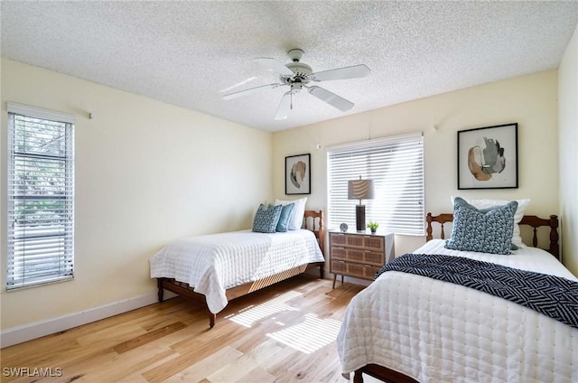 bedroom featuring ceiling fan, a textured ceiling, and light hardwood / wood-style floors