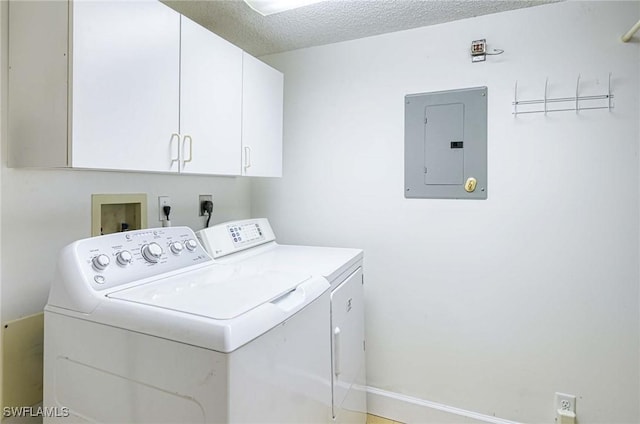 washroom featuring cabinets, a textured ceiling, electric panel, and washer and dryer