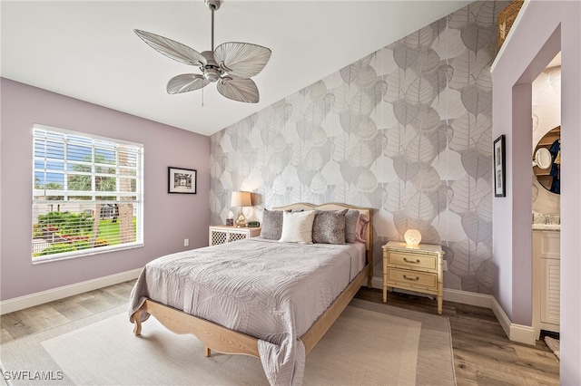 bedroom with ceiling fan, ensuite bathroom, and wood-type flooring