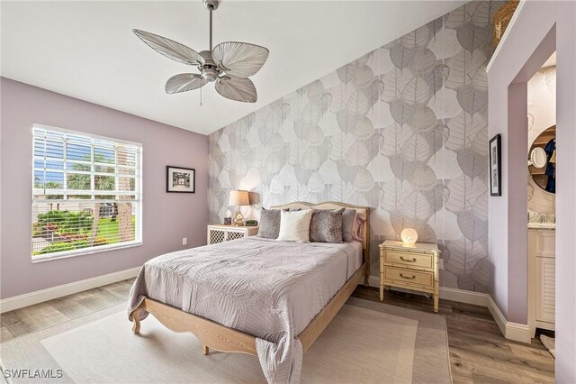 648 Mardel Ct Unit 708, Naples, FL 34104 - bedroom featuring an accent wall, baseboards, wood finished floors, wallpapered walls, and ceiling fan