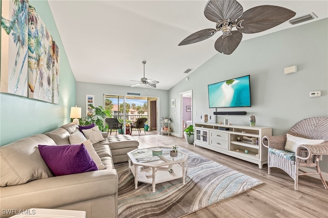 living room with light wood-type flooring and vaulted ceiling