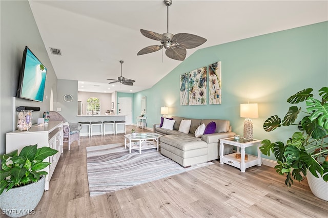 living room with light wood-type flooring, vaulted ceiling, and ceiling fan