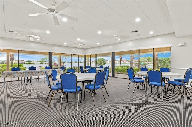 dining area featuring carpet floors, plenty of natural light, a paneled ceiling, and ceiling fan