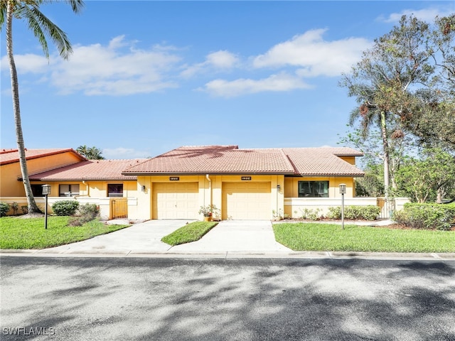 ranch-style house with a garage and a front lawn