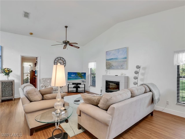 living room featuring ceiling fan, light hardwood / wood-style floors, and lofted ceiling