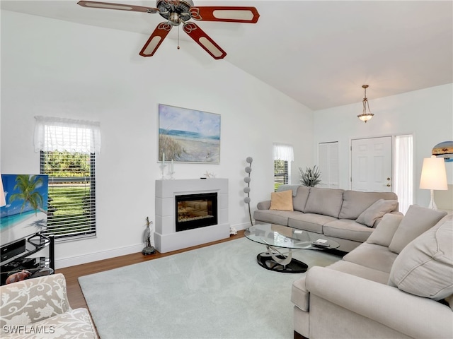 living room featuring ceiling fan, wood-type flooring, and vaulted ceiling