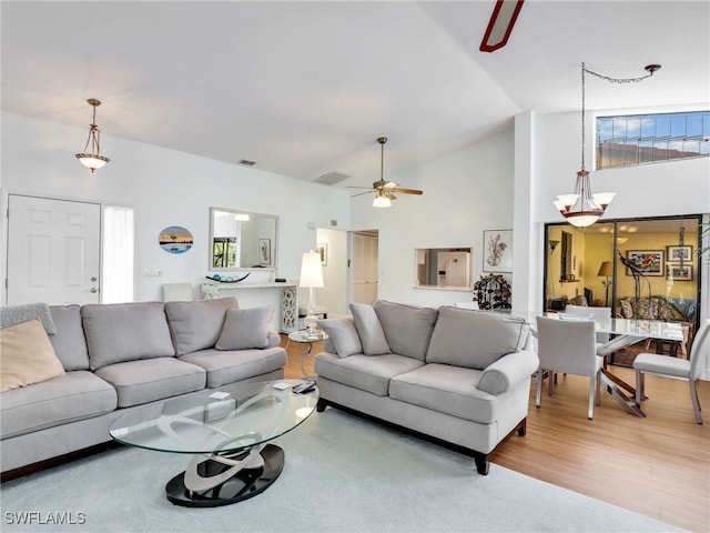 living room featuring ceiling fan, light hardwood / wood-style floors, and high vaulted ceiling