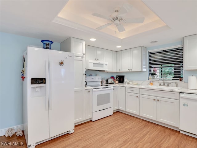 kitchen with white cabinets, white appliances, sink, and a tray ceiling