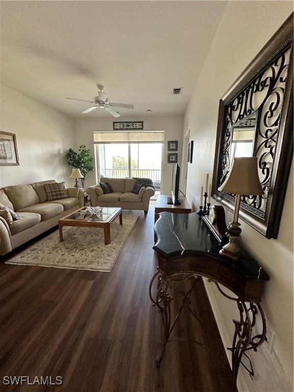 living room with ceiling fan, a textured ceiling, and dark hardwood / wood-style flooring