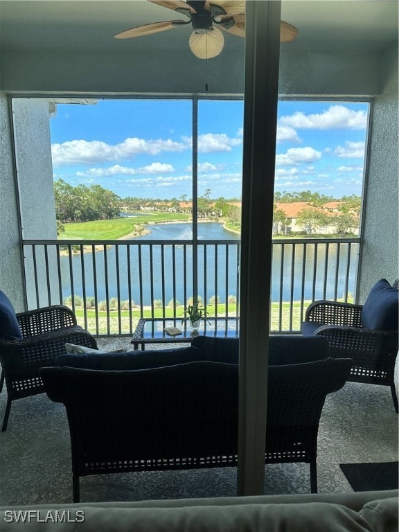 sunroom with a wealth of natural light, ceiling fan, and a water view