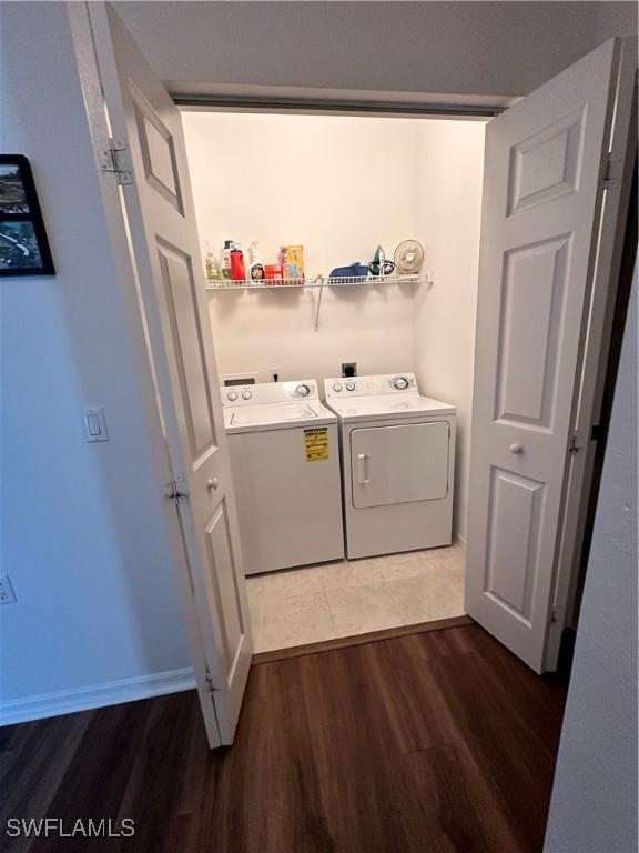 washroom featuring washing machine and dryer and dark hardwood / wood-style floors