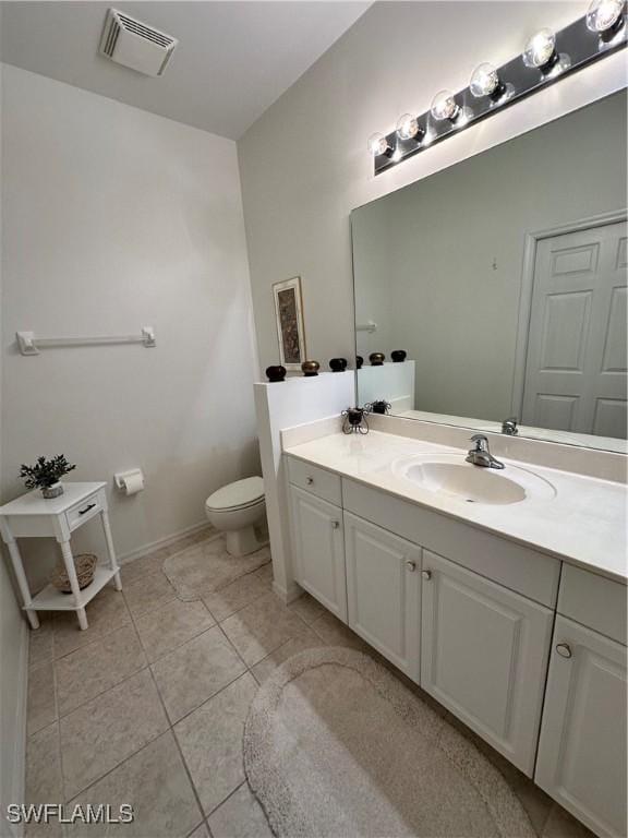 bathroom featuring vanity, tile patterned floors, and toilet