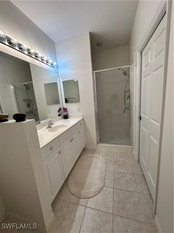 bathroom featuring vanity, an enclosed shower, and tile patterned flooring