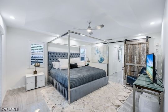 bedroom featuring a barn door and ceiling fan