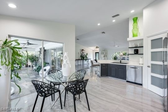 dining room featuring ceiling fan, lofted ceiling, and sink