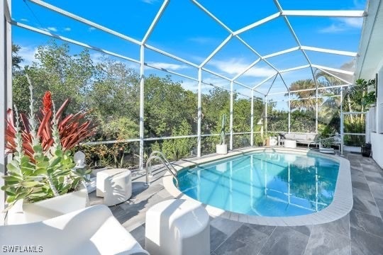 view of pool with glass enclosure and a patio