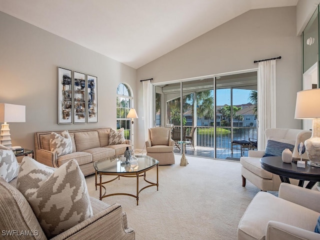 carpeted living room with a water view, high vaulted ceiling, and a wealth of natural light