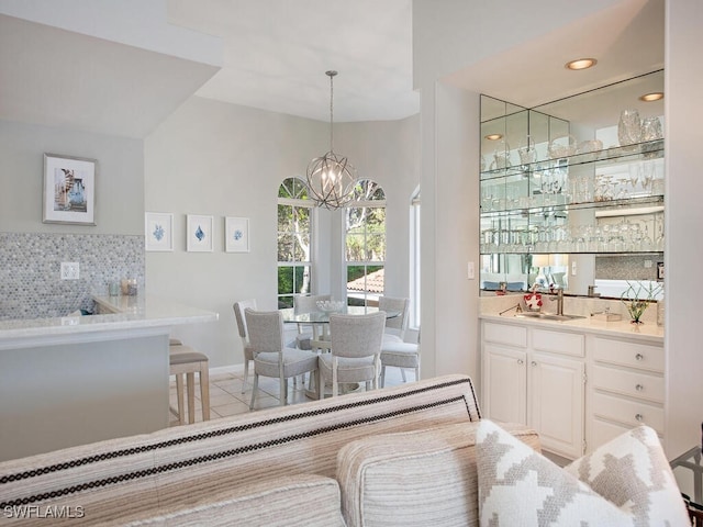 tiled dining area featuring sink and an inviting chandelier