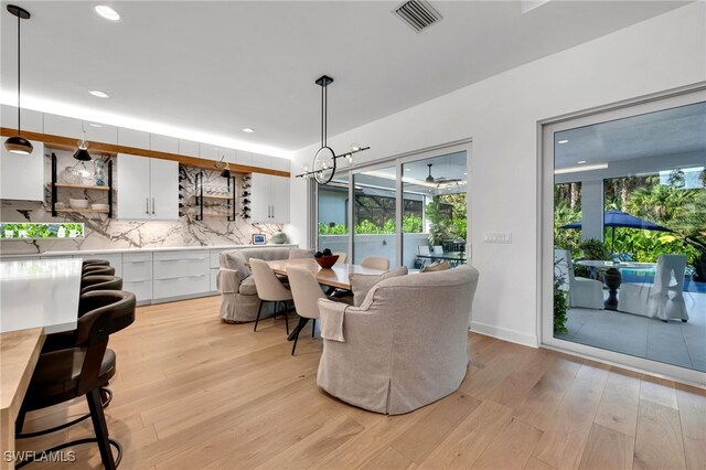 dining room featuring light wood-type flooring, visible vents, plenty of natural light, and recessed lighting