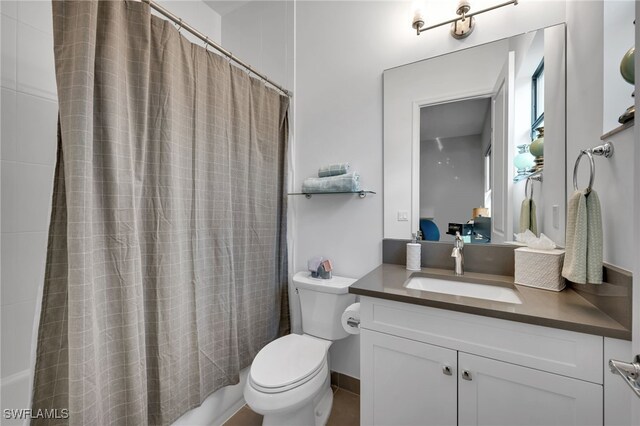 bathroom featuring toilet, shower / bath combination with curtain, and vanity