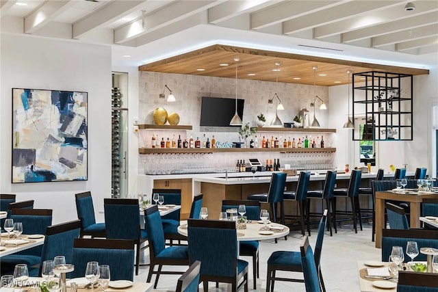 bar with a community bar, beam ceiling, hanging light fixtures, and decorative backsplash