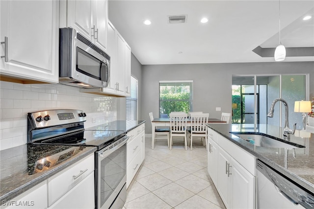 kitchen featuring stainless steel appliances, white cabinetry, and sink