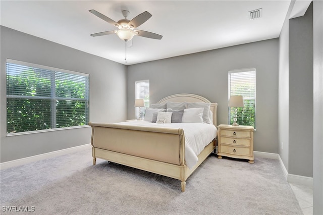 carpeted bedroom featuring multiple windows and ceiling fan