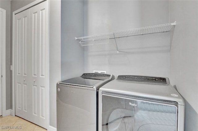 clothes washing area with light tile patterned floors and washing machine and dryer