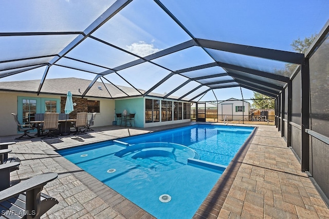 view of swimming pool with a patio, a shed, and a lanai