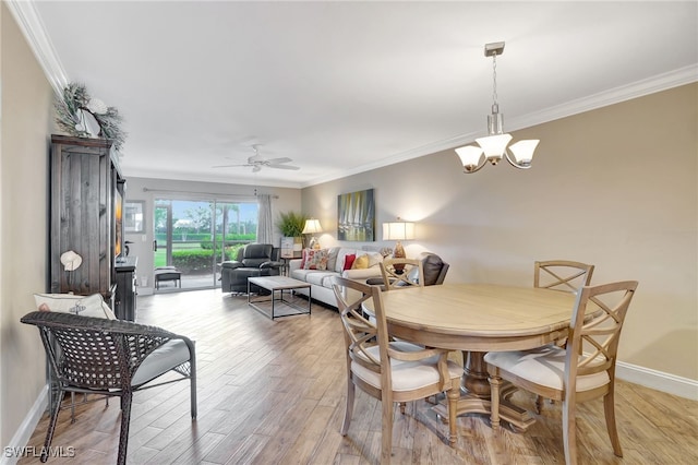 dining space featuring light wood-type flooring, ceiling fan with notable chandelier, and ornamental molding