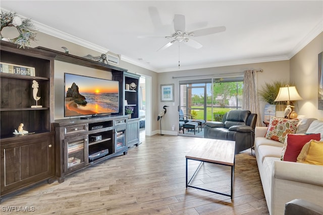 living area featuring baseboards, light wood finished floors, a ceiling fan, and crown molding