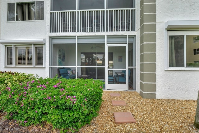 doorway to property featuring a balcony and stucco siding