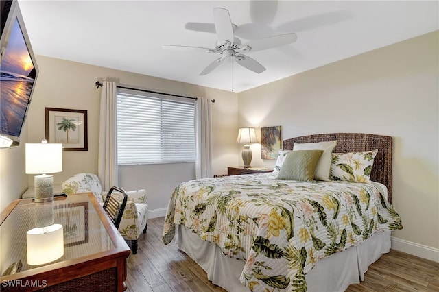 bedroom with ceiling fan, baseboards, and wood finished floors