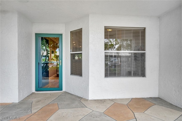 view of exterior entry with a patio