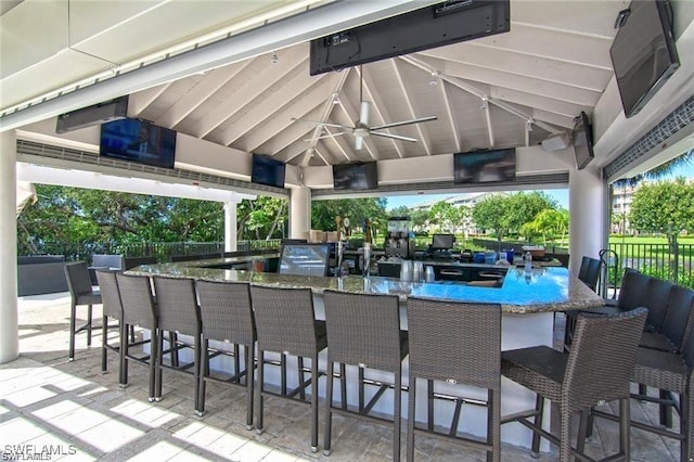 view of patio with outdoor wet bar, a ceiling fan, and a gazebo