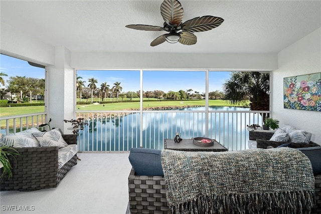 sunroom / solarium with a water view and ceiling fan