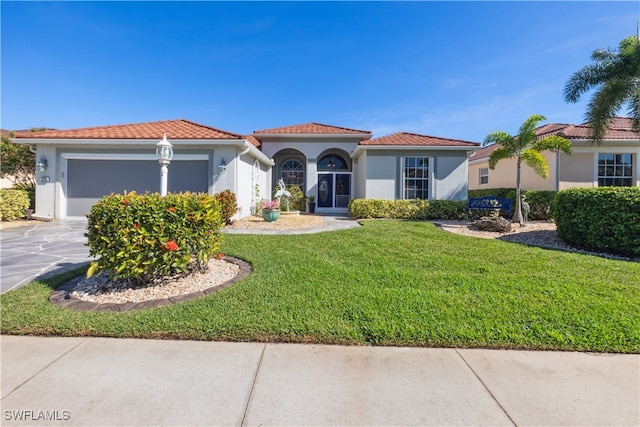 mediterranean / spanish-style house featuring a front yard and a garage