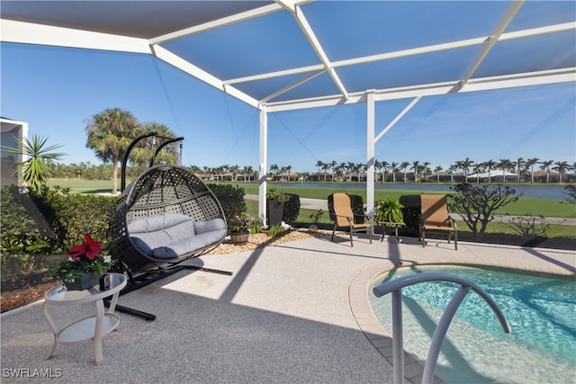 view of pool with a patio, a water view, and glass enclosure