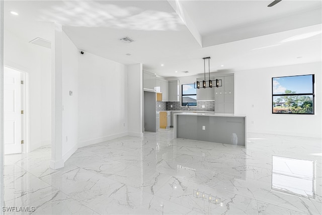 kitchen featuring decorative light fixtures, a center island, a wealth of natural light, and tasteful backsplash