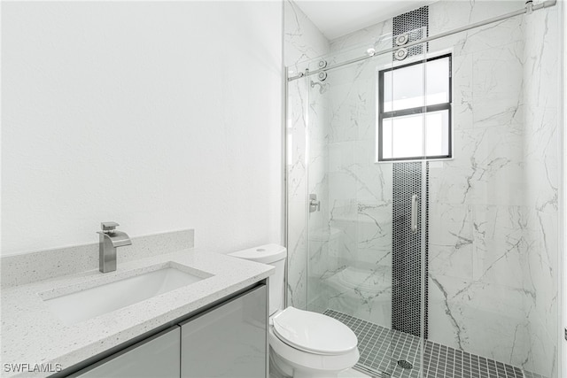 bathroom featuring vanity, toilet, and a shower with door