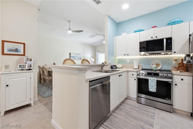 kitchen featuring sink, kitchen peninsula, white cabinets, and appliances with stainless steel finishes