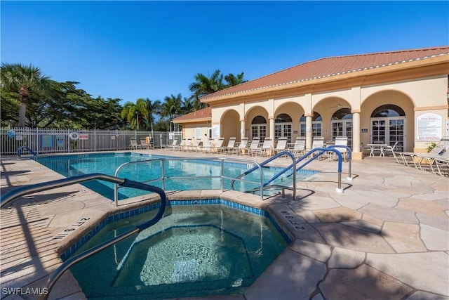 view of swimming pool featuring a hot tub and a patio area