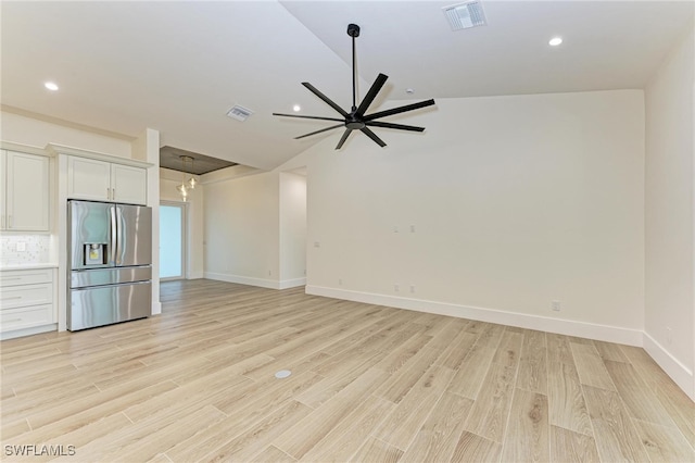 unfurnished living room featuring ceiling fan, lofted ceiling, and light wood-type flooring