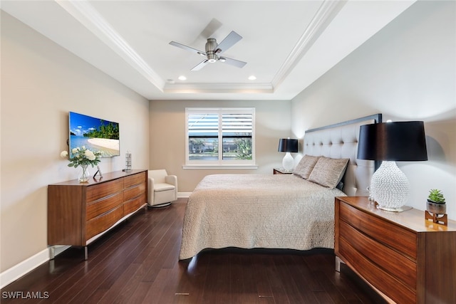 bedroom with dark hardwood / wood-style floors, crown molding, ceiling fan, and a tray ceiling