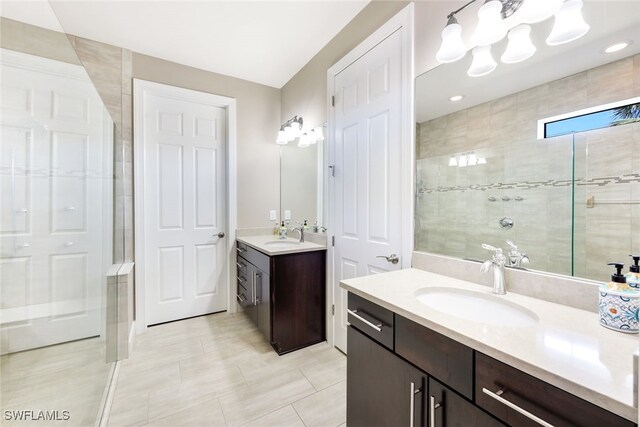 bathroom featuring tile patterned floors, vanity, and a tile shower