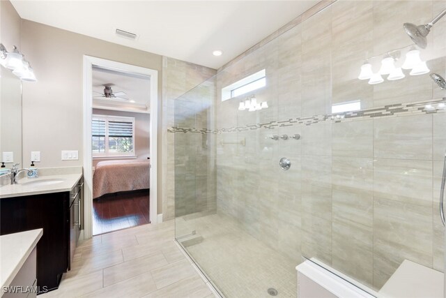 bathroom featuring hardwood / wood-style flooring, vanity, ceiling fan, and tiled shower