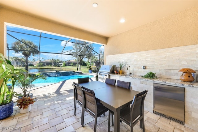 view of patio / terrace with glass enclosure, exterior kitchen, sink, and grilling area