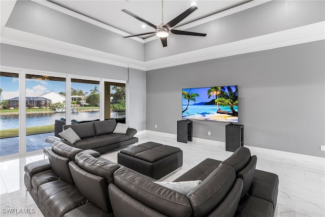 living room with a towering ceiling, a water view, ceiling fan, and ornamental molding